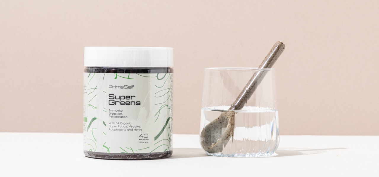 PrimeSelf Organic Super Greens tub on a kitchen counter