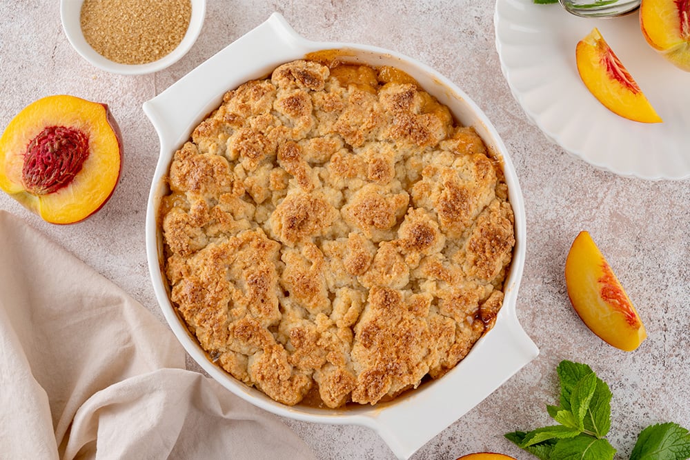 Pregnancy-friendly dessert cobbler for expecting moms laid out on a table with peaches