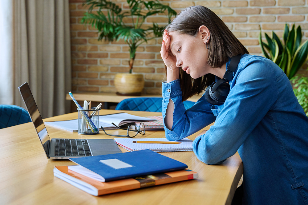Women with her head in head hand in front of laptop