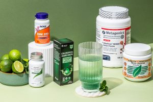 Natural detox and cleanse supplements including chlorophyll drops, liver support and intestinal cleanse displayed with citrus and a glass of green drink.