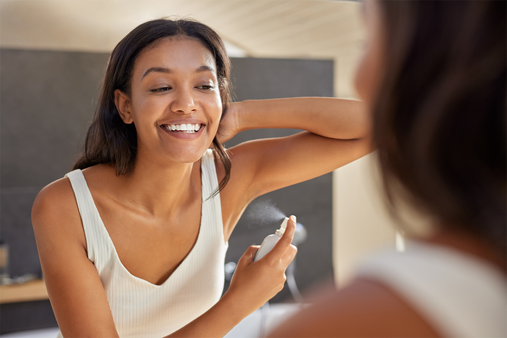 Smiling women using natural aerosol deodorant